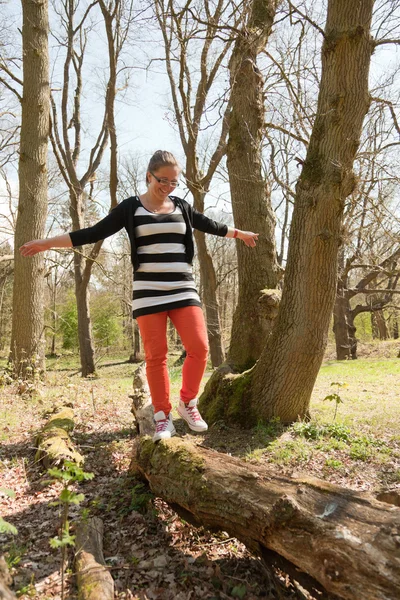 Single happy young woman walking on tree. — Stock Photo, Image