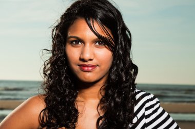 Yaz aylarında sahilde uzun saçlı güzel Hintli kız.