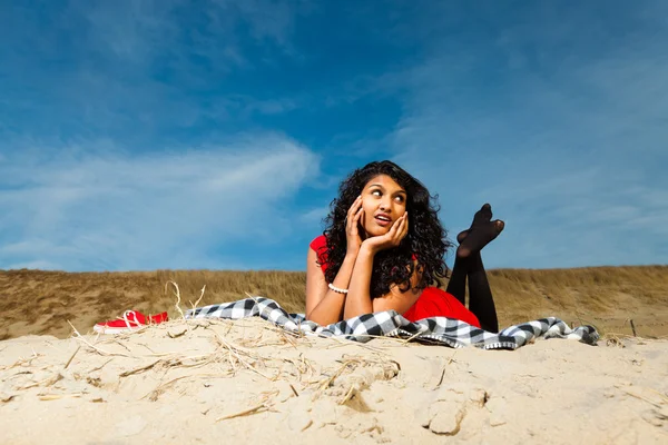 Ragazza indiana con i capelli lunghi vestita di rosso sulla spiaggia in estate — Foto Stock