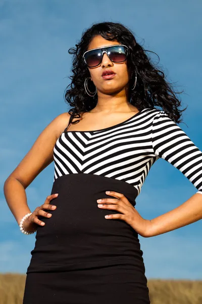 Vrij Indiase meisje met zonnebril op het strand in de zomer. — Stockfoto