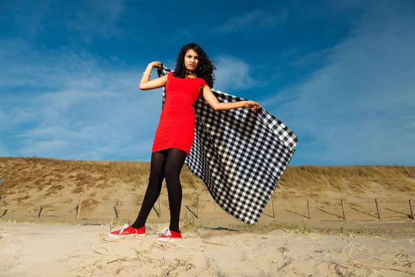 Indian girl with long hair dressed in red on the beach in summer — Stock Photo, Image