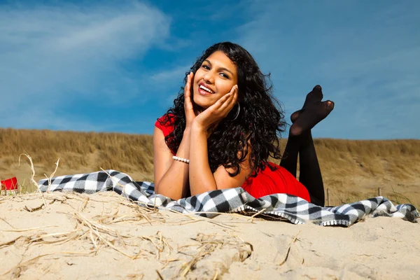 Intialainen tyttö pitkät hiukset pukeutunut punaiseen rannalla kesällä — kuvapankkivalokuva
