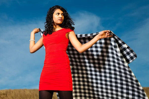 Indiase meisje met lange haren gekleed in het rood op het strand in de zomer — Stockfoto