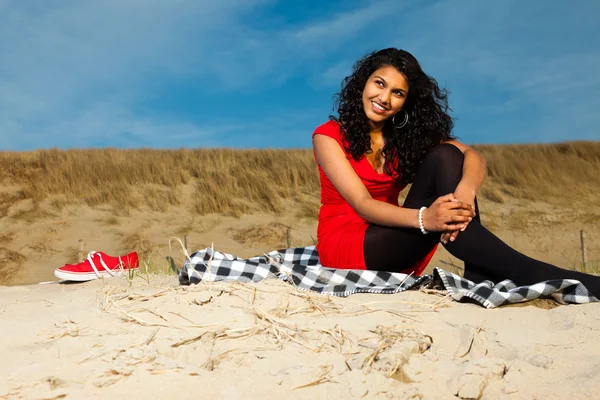 Ragazza indiana con i capelli lunghi vestita di rosso sulla spiaggia in estate — Foto Stock