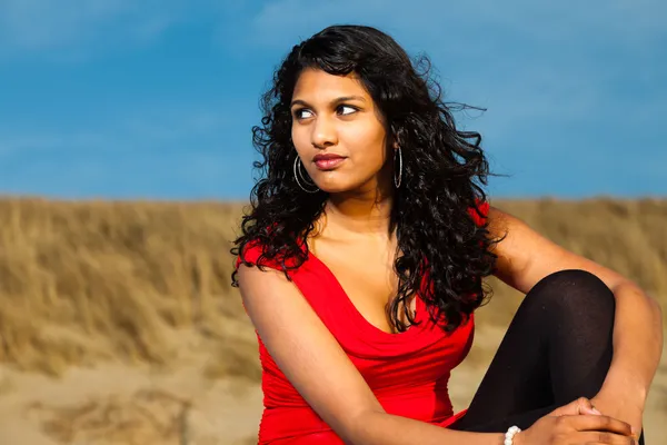 Chica india con el pelo largo vestido de rojo en la playa en verano — Foto de Stock