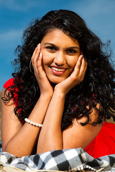 Ragazza indiana con i capelli lunghi vestita di rosso sulla spiaggia in estate — Foto Stock