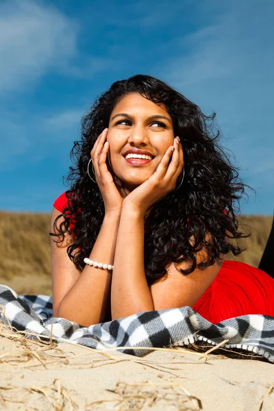 Indian girl with long hair dressed in red on the beach in summer — Stock Photo, Image