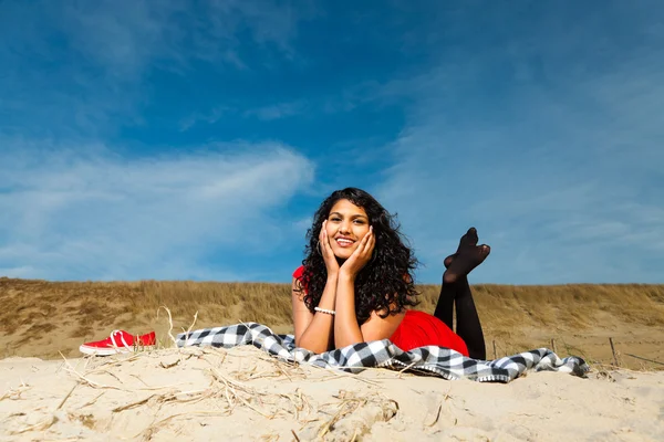 Indian girl with long hair dressed in red on the beach in summer — Stock Photo, Image