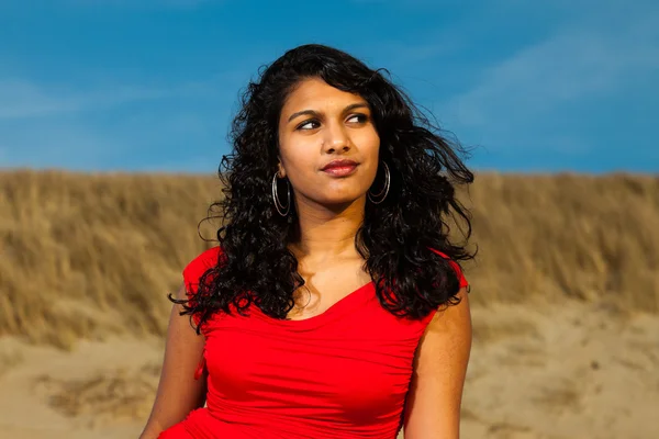 Chica india con el pelo largo vestido de rojo en la playa en verano —  Fotos de Stock