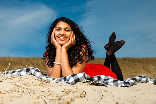 Yaz aylarında sahilde kırmızı giymiş uzun saçlı Hintli kız