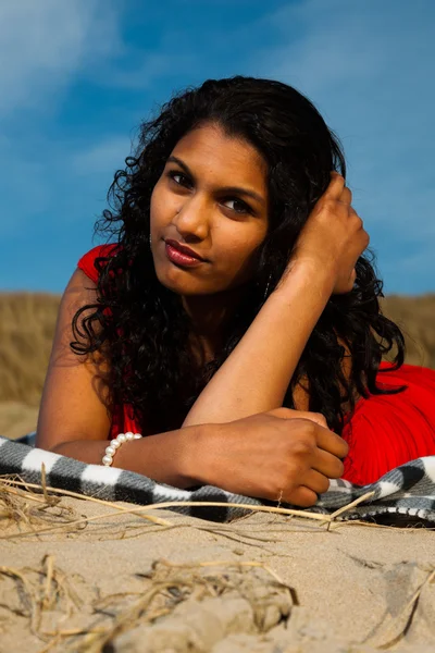 Indian girl with long hair dressed in red on the beach in summer — Stock Photo, Image