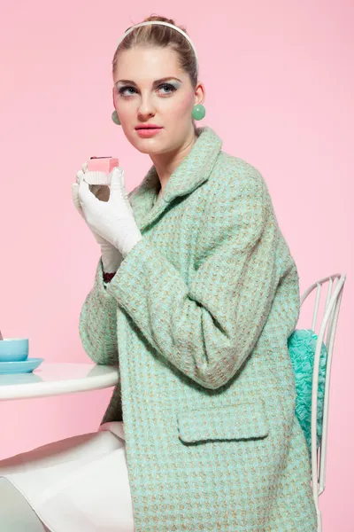 Girl blonde hair fifties fashion style eating cup cake. — Stock Photo, Image