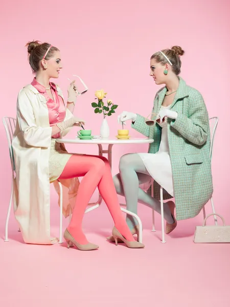 Two girls blonde hair fifties fashion style drinking tea. — Stock Photo, Image