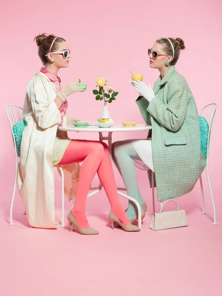Two girls blonde hair fifties fashion style drinking tea. — Stock Photo, Image