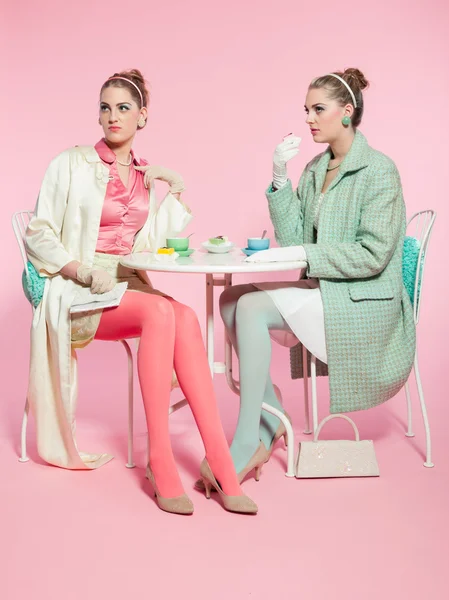 Två flickor blonda hår femtiotalet mode stil dricka te. — Stockfoto