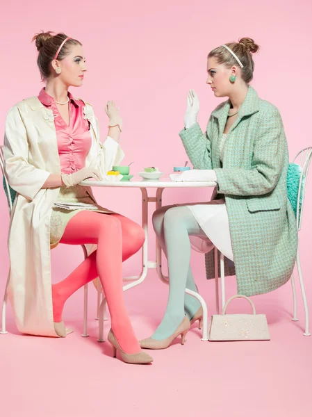 Dwie dziewczyny blond włosy pięćdziesiątych moda styl picia herbaty. — Zdjęcie stockowe