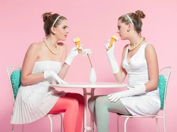 Dos chicas cabello rubio cincuenta estilo de moda comiendo helado . — Foto de Stock