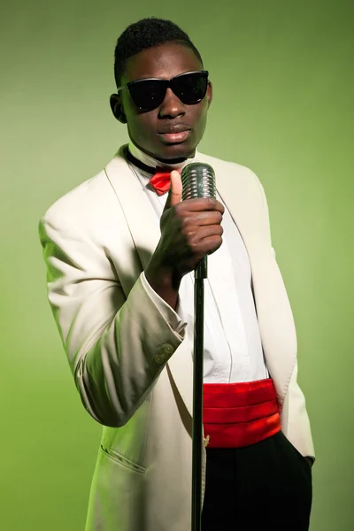 Éneklő fekete amerikai ember napszemüveget visel öltönyt. Vintage. — Stock Fotó