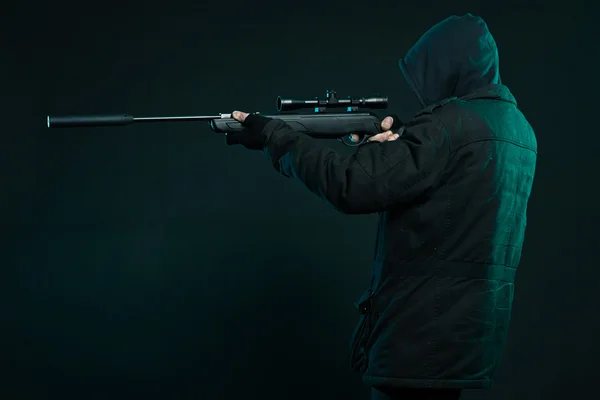 Sniper with beard in black holding gun. Studio shot. — Stock Photo, Image