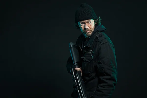 Снайпер с бородой в черном держит пистолет. Снимок студии . — стоковое фото