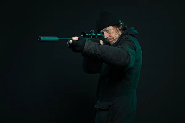 Снайпер с бородой в черном держит пистолет. Снимок студии . — стоковое фото