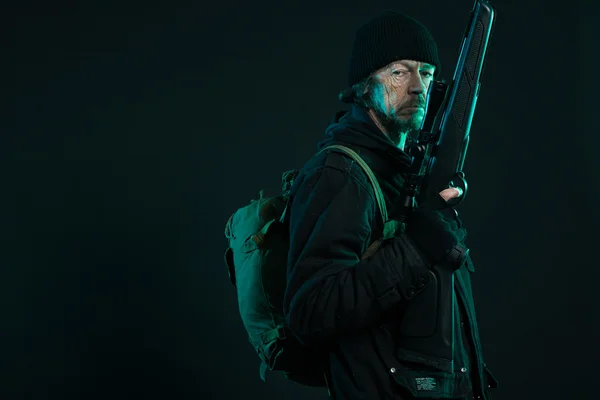 Sniper met baard in zwarte bedrijf pistool. studio opname. — Stockfoto