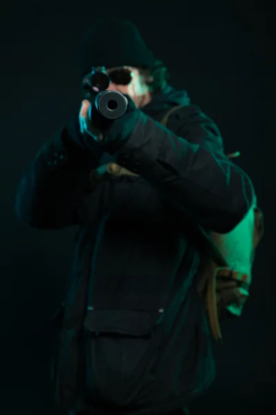 Sniper with beard in black holding gun. Studio shot. — Stock Photo, Image