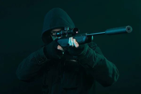 Sniper met baard in zwarte bedrijf pistool. studio opname. — Stockfoto