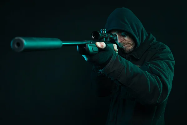 Sniper with beard in black holding gun. Studio shot. — Stock Photo, Image