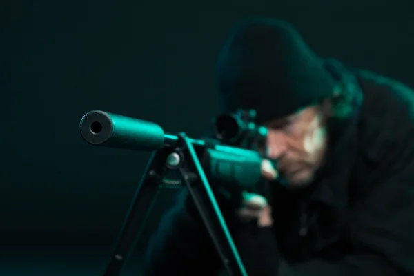 Sniper with beard in black holding gun. Studio shot. — Stock Photo, Image