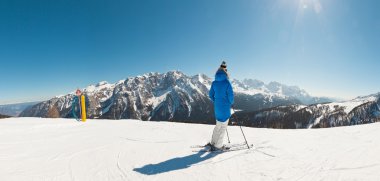 Panorama of winter sport snow mountain landscape with ski woman. clipart