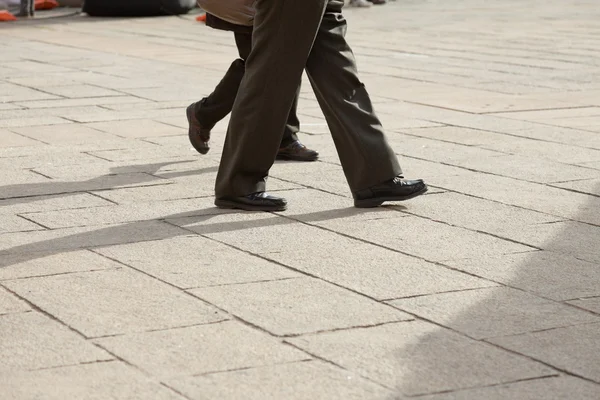 Nohy starší pár, chůzi na ulici. Itálie. Evropa. — Stock fotografie