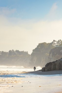 Sahilde yürüyüş yalnız sörfçü. Malibu. Amerika Birleşik Devletleri. Kaliforniya.