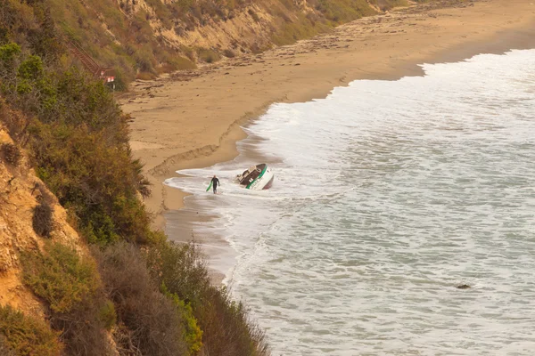 孤独なサーファーは、ビーチの上を歩いてします。マリブです。米国。カリフォルニア州. — ストック写真