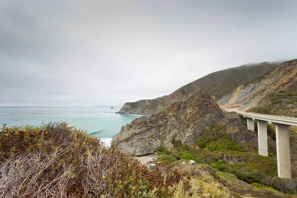 Coast of Big Sur with highway and cloudy sky. USA. California. — Stock Photo, Image