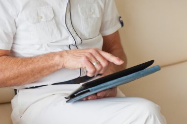 Komuta sizde gözlüklü oturma odasında kanepede tablet kullanma.