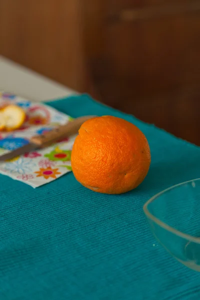 Orange with knife and dish on table. — Stock Photo, Image