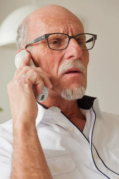Homme âgé appelant avec téléphone portable dans le salon . — Photo