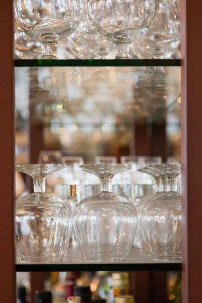 Empty wine glasses in bar rack. — Stock Photo, Image