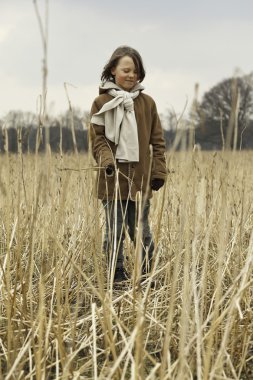 uzun saçlı buğday alanında açık eğlenceli komik çocuk.