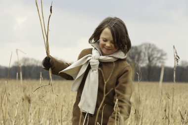 uzun saçlı buğday alanında açık eğlenceli komik çocuk.