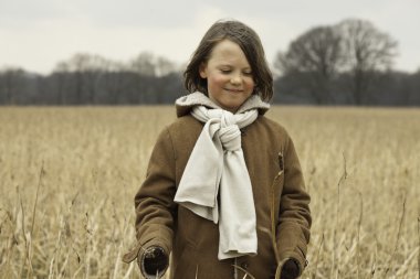 uzun saçlı buğday alanında açık eğlenceli komik çocuk.