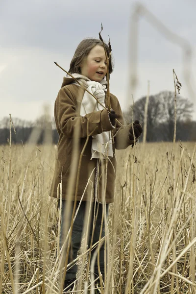 Hravé legrační mladík s dlouhými vlasy venkovním v pšeničné pole. — Stock fotografie