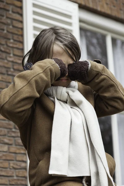 Verspielter lustiger kleiner Junge mit langen Haaren draußen vor dem Haus — Stockfoto