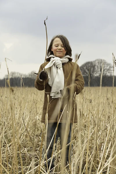 Hravé legrační mladík s dlouhými vlasy venkovním v pšeničné pole. — Stock fotografie