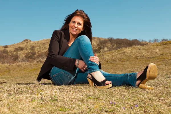 Smiling pretty brunette woman wearing brown jacket. Sitting in m — Stock Photo, Image