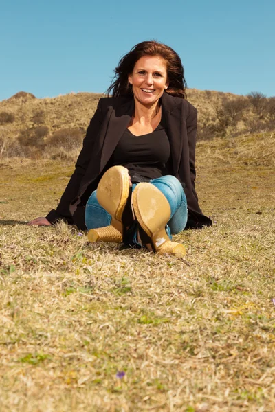 Sorridente bella donna bruna indossa giacca marrone. Seduto in m — Foto Stock