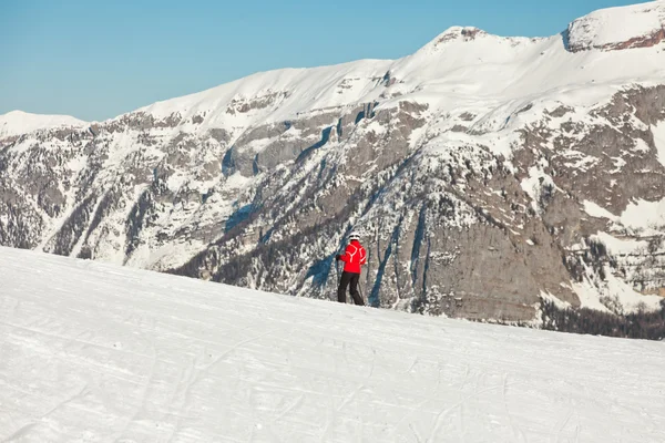 Eenzame skiën toerist in sneeuw berglandschap met blauwe hemel. — Stockfoto