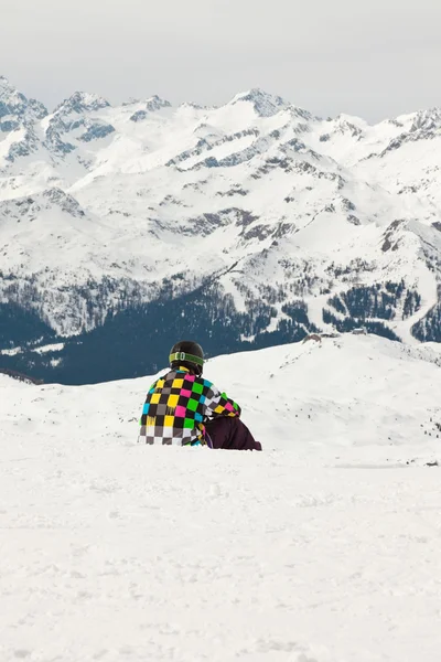 スノーボーダーは雪の中で座っています。ロッキー山の風景. — ストック写真