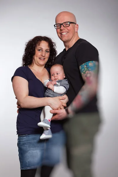 Lyckliga paret håller sitt barn. Studio skott. — Stockfoto